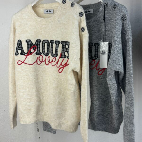 Maglione con dettaglio di bottoni e scritta