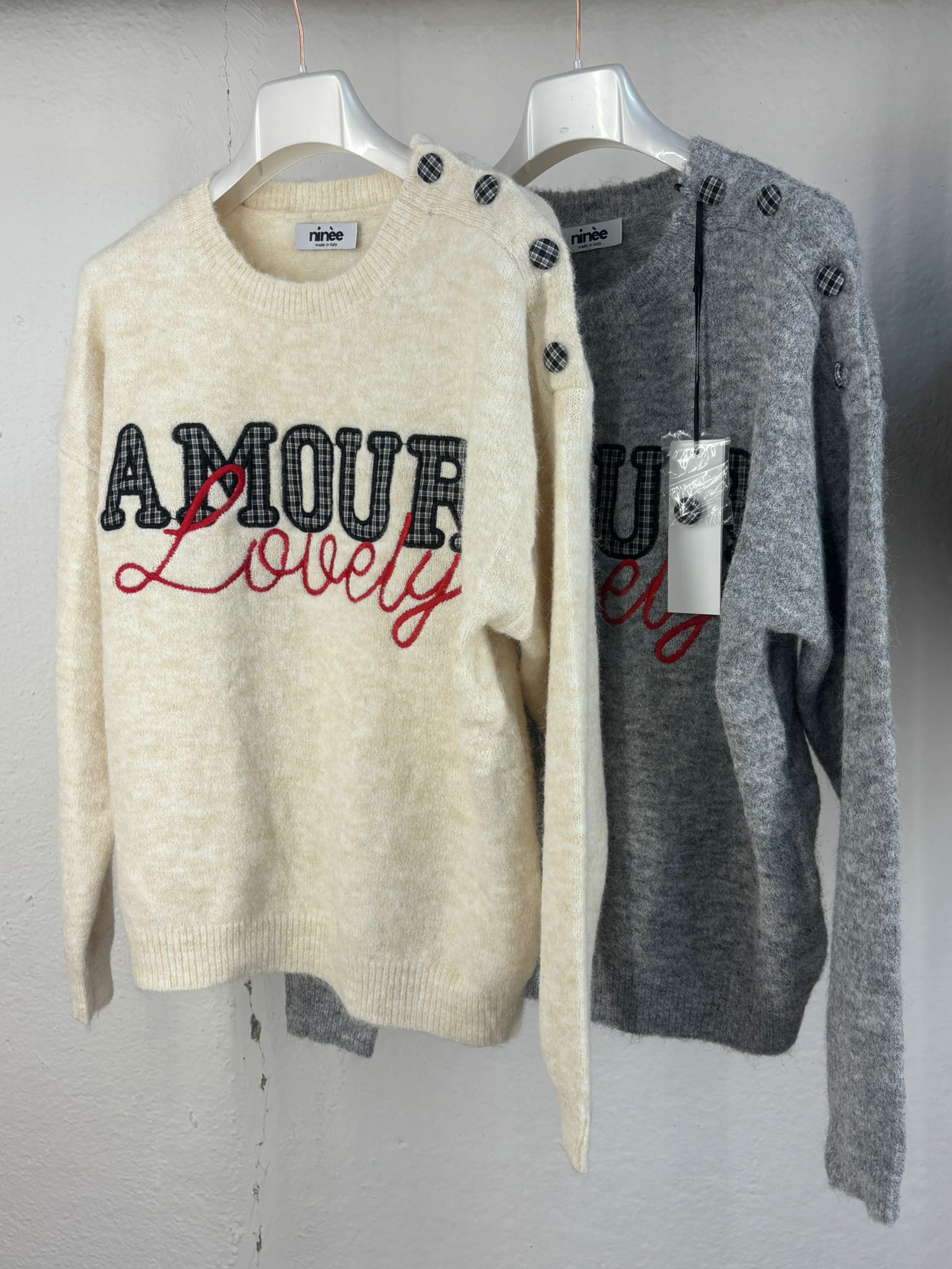 Maglione con dettaglio di bottoni e scritta