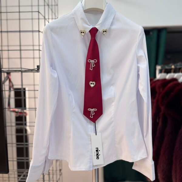 Camicia con cravatta e spille decorative nella parte frontale